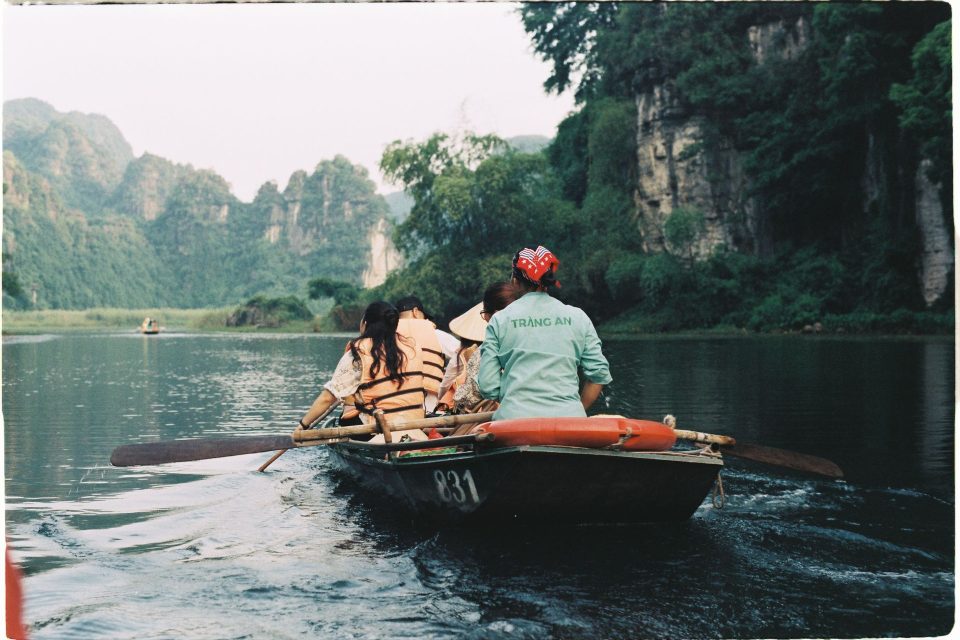 Enjoy a tranquil boat ride through stunning cliffs and lush greenery in Trang An, Vietnam.