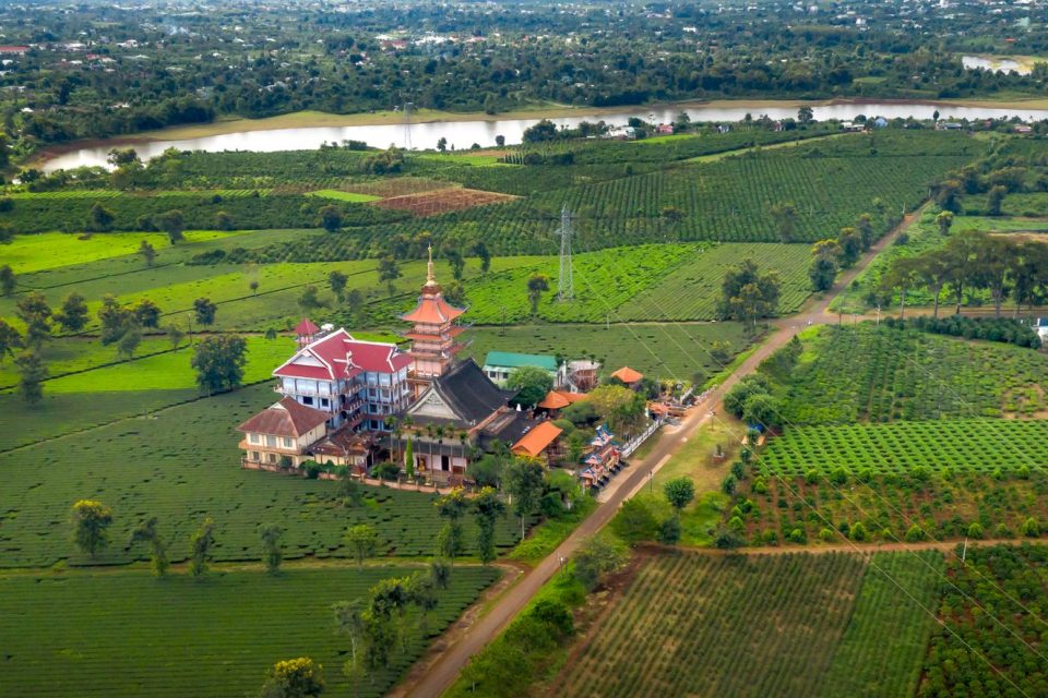Stunning aerial view of Buu Minh Pagoda surrounded by lush farmland in Gia Lai, Vietnam.