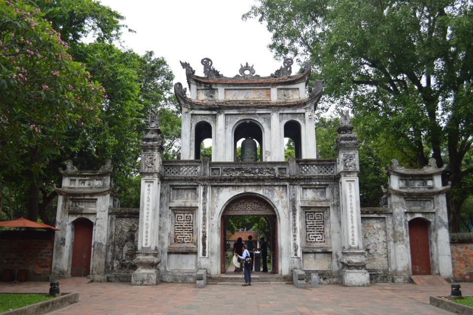 Explore the historic entrance of the Temple of Literature in Hanoi, surrounded by lush greenery.
