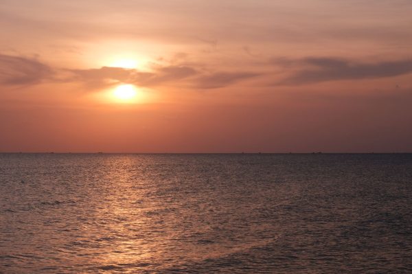 Serene sunset over the sea in Phu Quoc, Vietnam, with warm hues and calming waves.