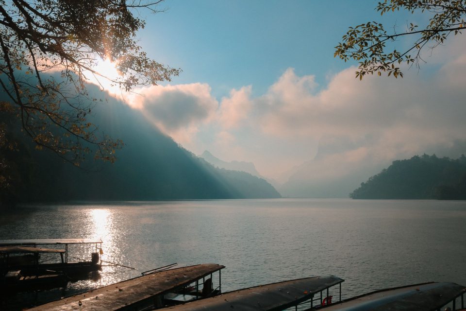 Serene morning view of a lake surrounded by misty mountains in Bắc Kạn, Vietnam. Tranquility and beauty captured.