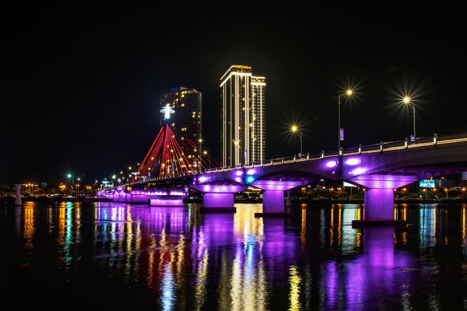 Stunning view of Da Nang's Dragon Bridge lit up with vibrant colors against the night sky.