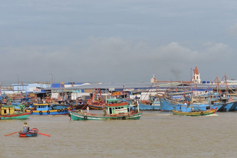 Scenic view of vibrant fishing boats docked at a bustling coastal fishing village.
