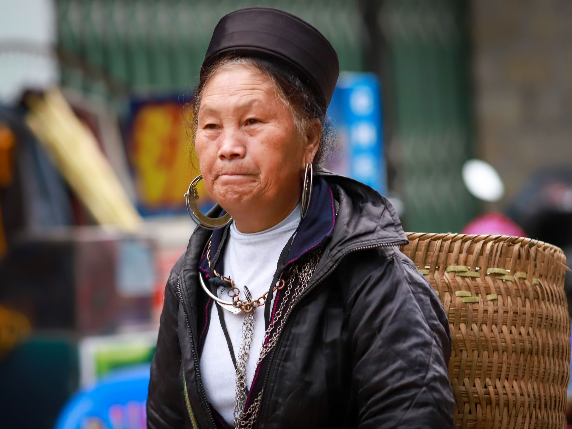 Portrait of an adult Hmong woman wearing traditional clothing at a market in Lào Cai, Vietnam.
