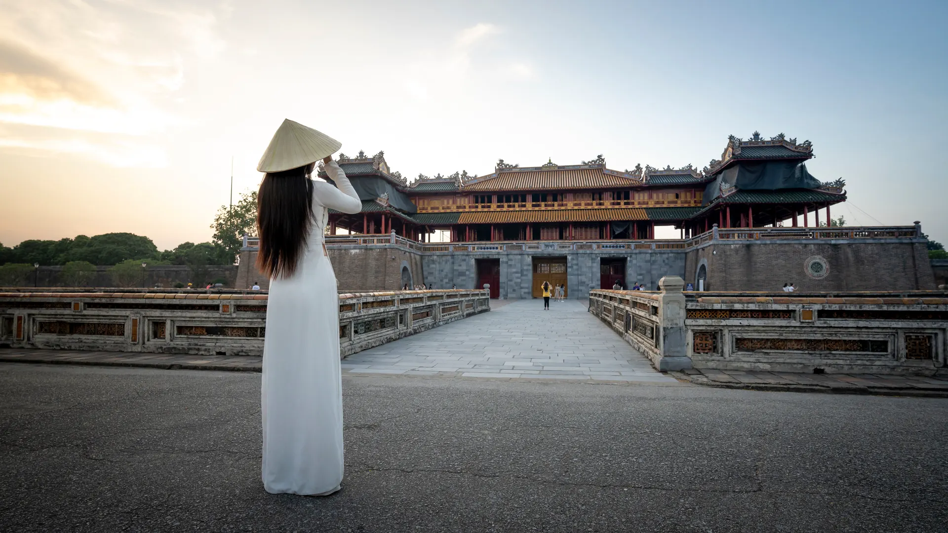 Cô gái mặc áo dài trắng, đội nón lá ngắm Ngọ Môn, Đại Nội Huế lúc hoàng hôn