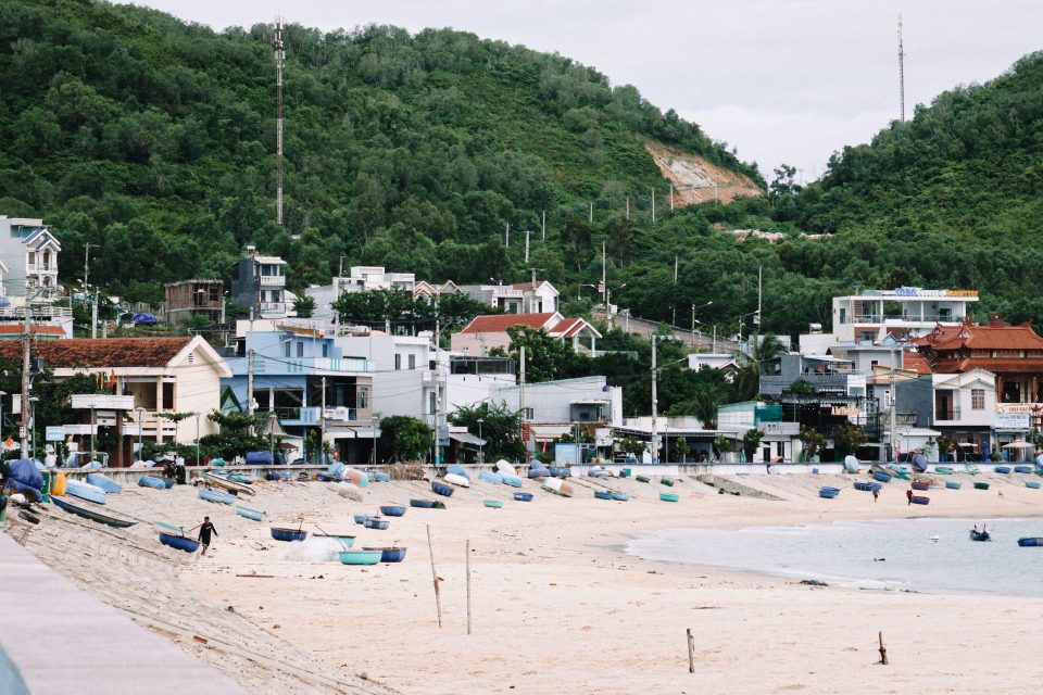 Scenic view of a beach and fishing village with boats in Quy Nhon, Vietnam.