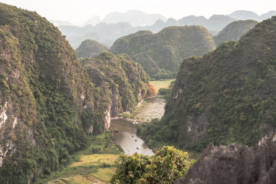Explore the lush limestone mountains and calm river in Nam Hoa Lu, Ninh Binh, Vietnam.