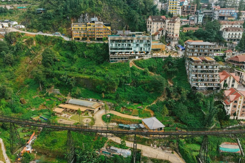 Aerial view of Sapa town featuring lush greenery and hillside architecture, Vietnam.