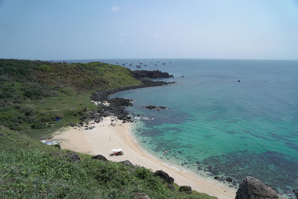Aerial view of a serene beach and turquoise ocean in Phan Thiết, Vietnam.