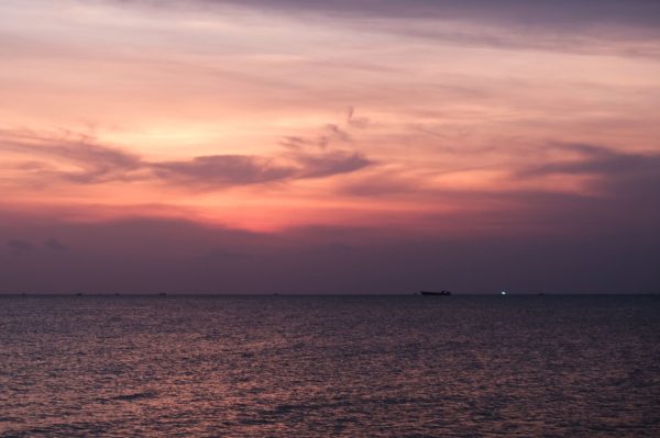 Beautiful sunset over the ocean in Phu Quoc, Vietnam. Vibrant sky reflecting on calm waters.
