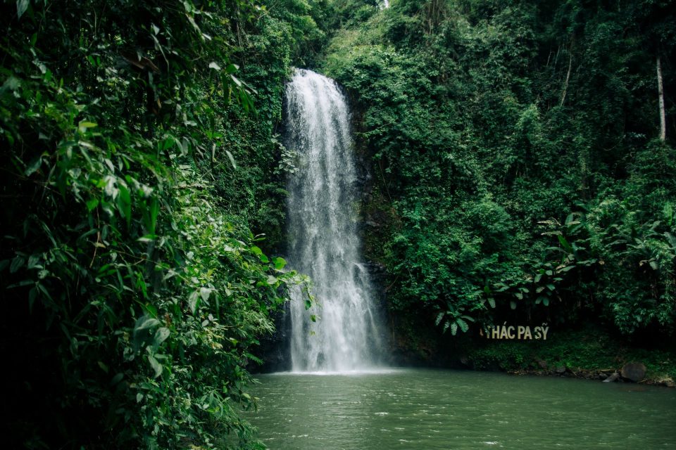 A tranquil waterfall surrounded by lush greenery in Kon Tum, Vietnam. Perfect for nature and travel imagery.