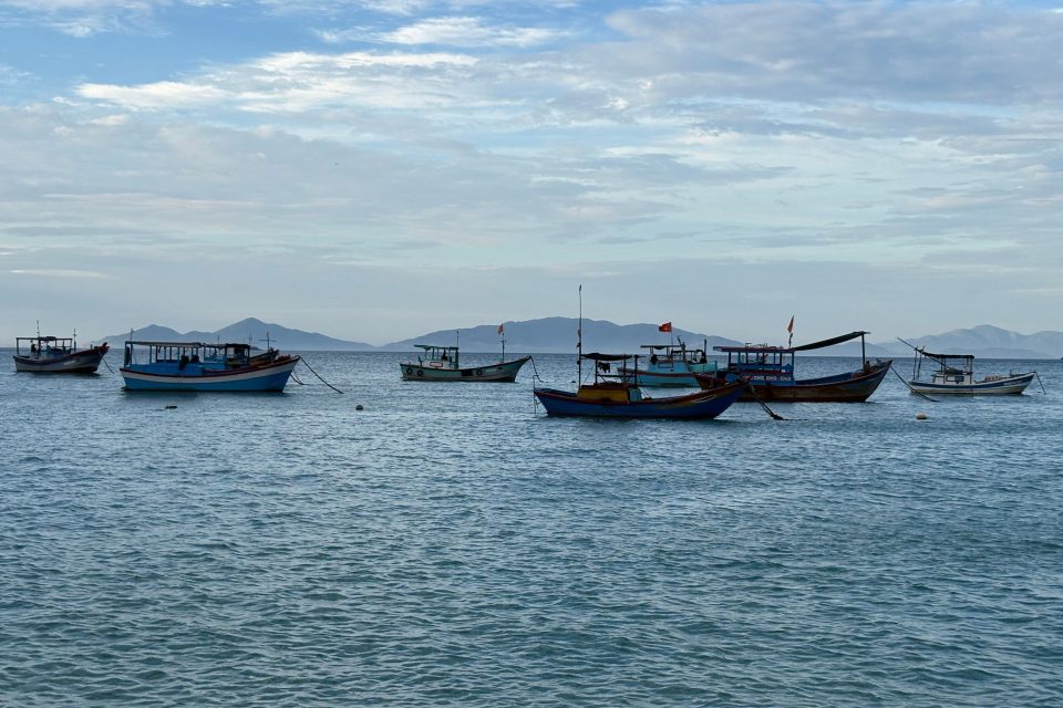 Scenic view of traditional fishing boats floating in Nha Trang Bay, Vietnam during a tranquil day.