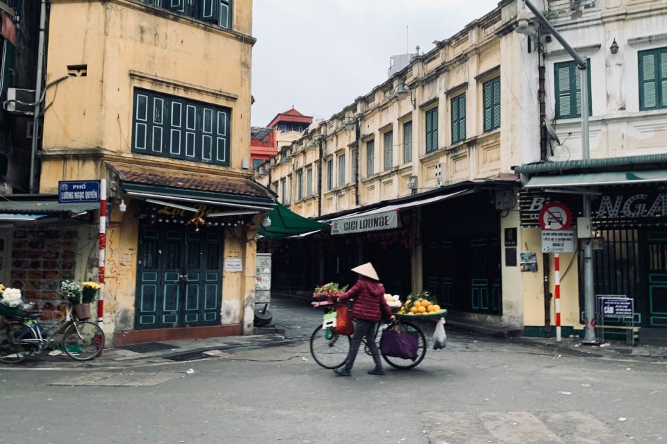 Street vendor with a bicycle in the urban market of Hanoi, Vietnam.
