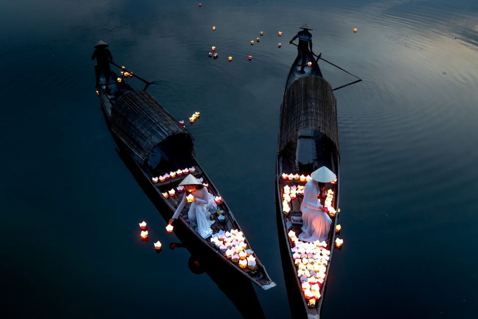 Peaceful scene of lantern-filled boats on a river at Hoi An Lantern Festival.